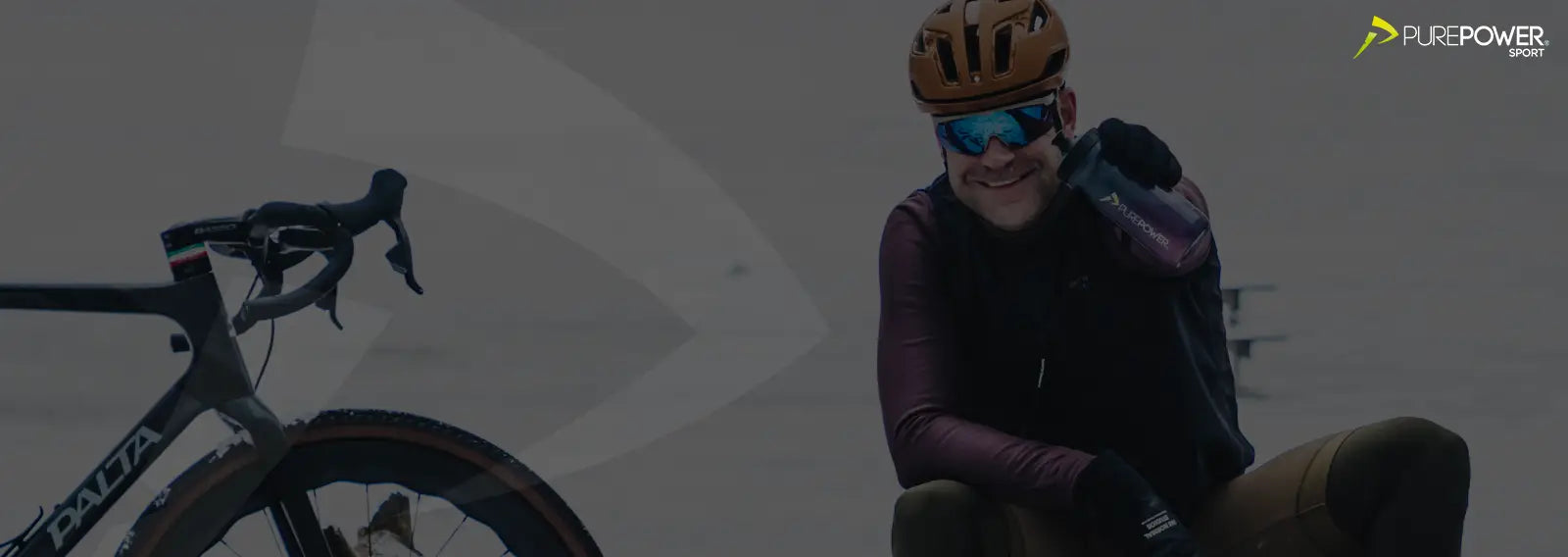 Mand med cykel, som viser en drikkedunk med elektrolytter i